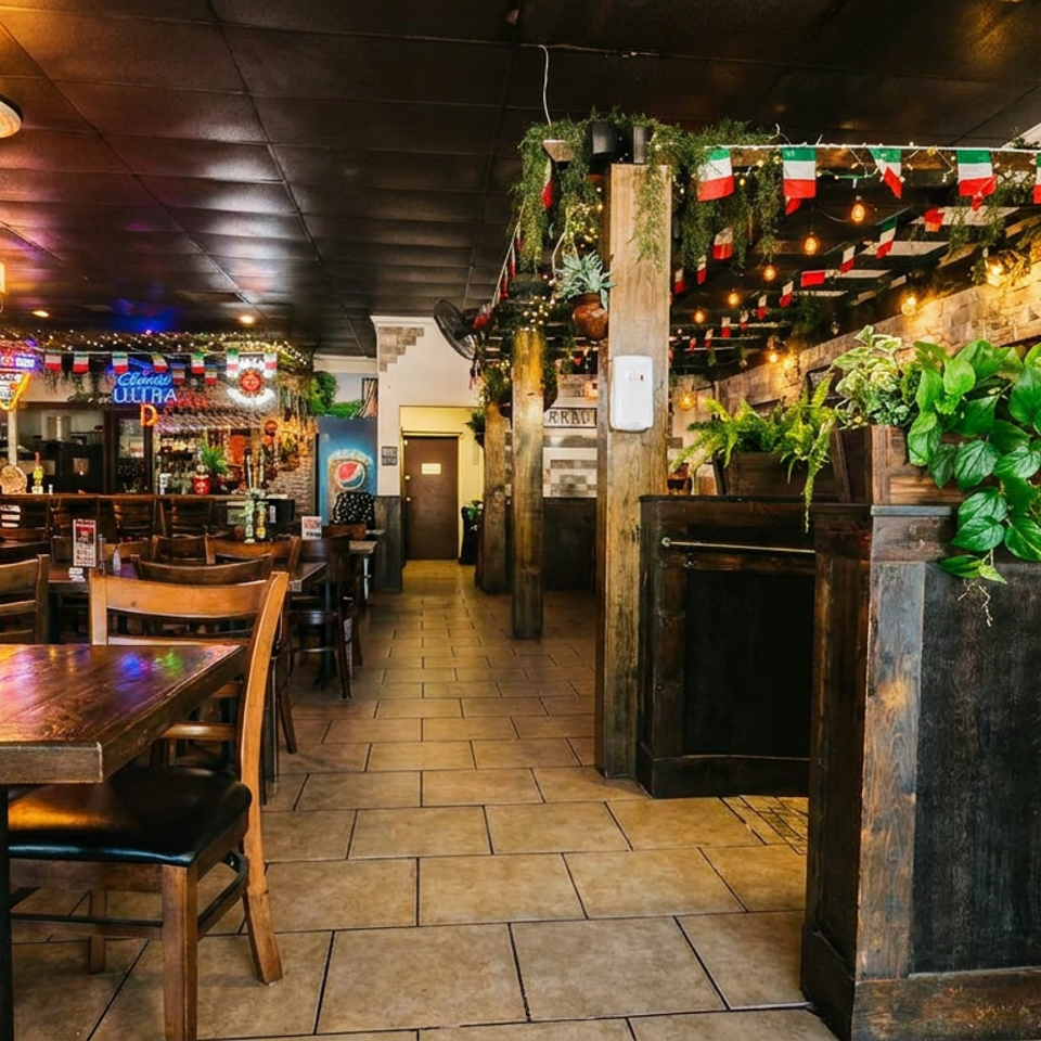 Cozy Italian restaurant interior with wooden tables, chairs, a bar, and Italian flag decorations.