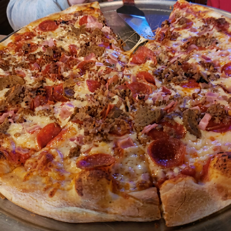 Meat-topped pizza with golden crust and melted cheese.
